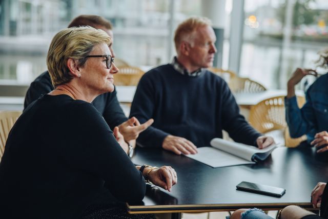 Oudere witte vrouw en man zittend in een overleg